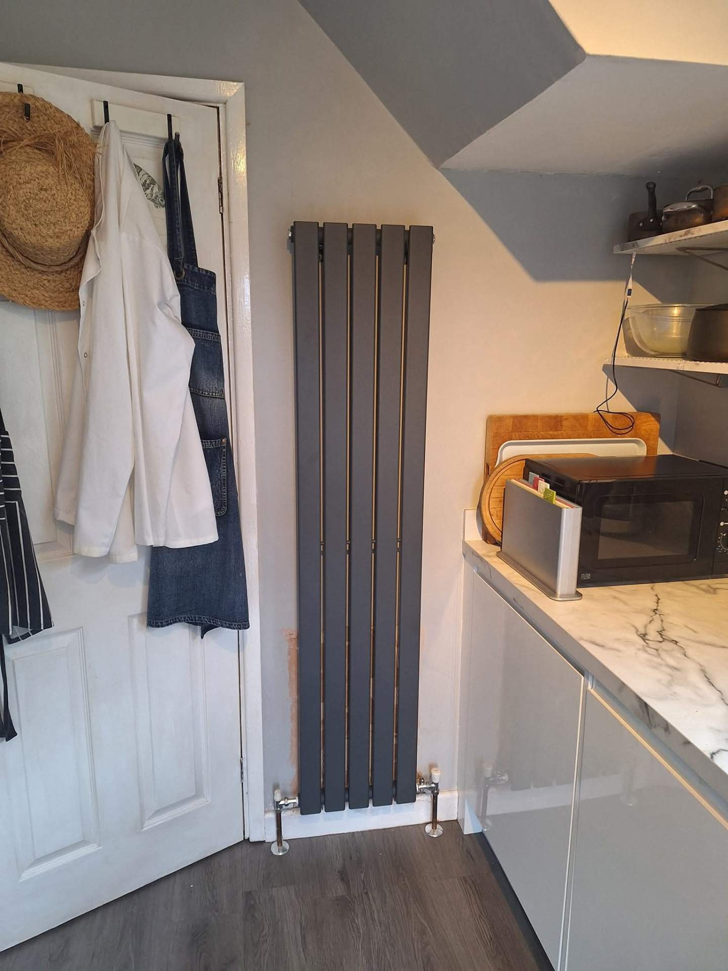 Anthracite vertical designer radiator installed in a modern kitchen by C Nixon Plumbing & Heating