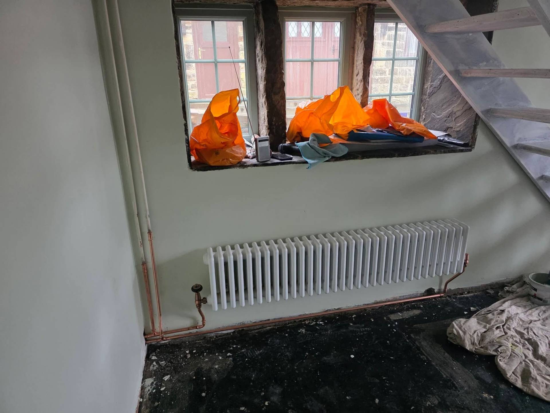 Replacement compact radiator installed under window with neat copper tails